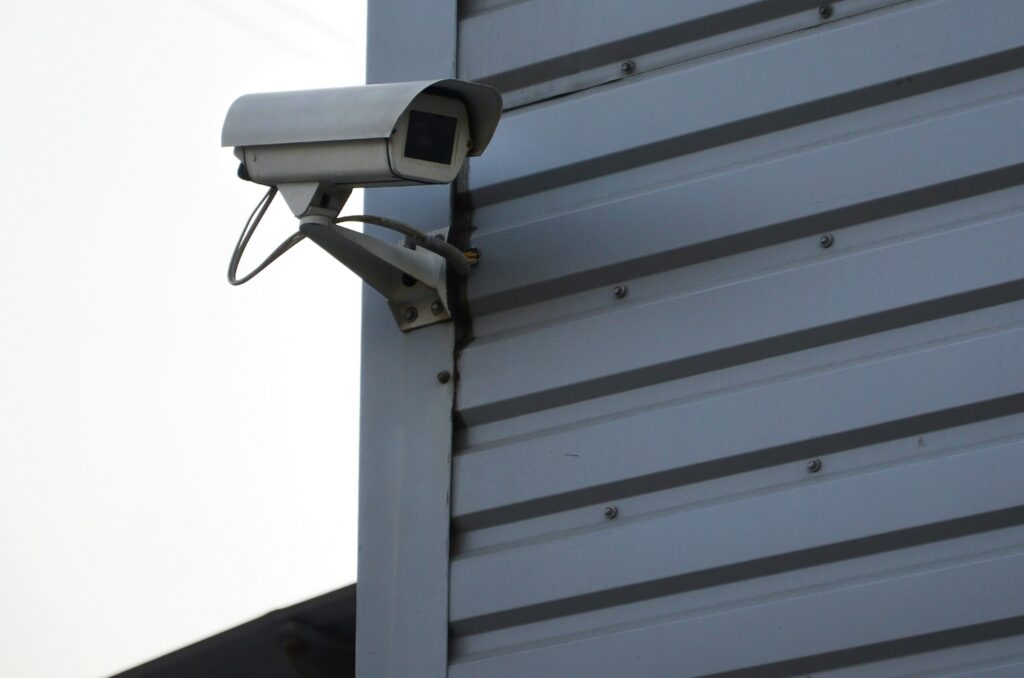 White surveillance camera built into the metal wall of the office building